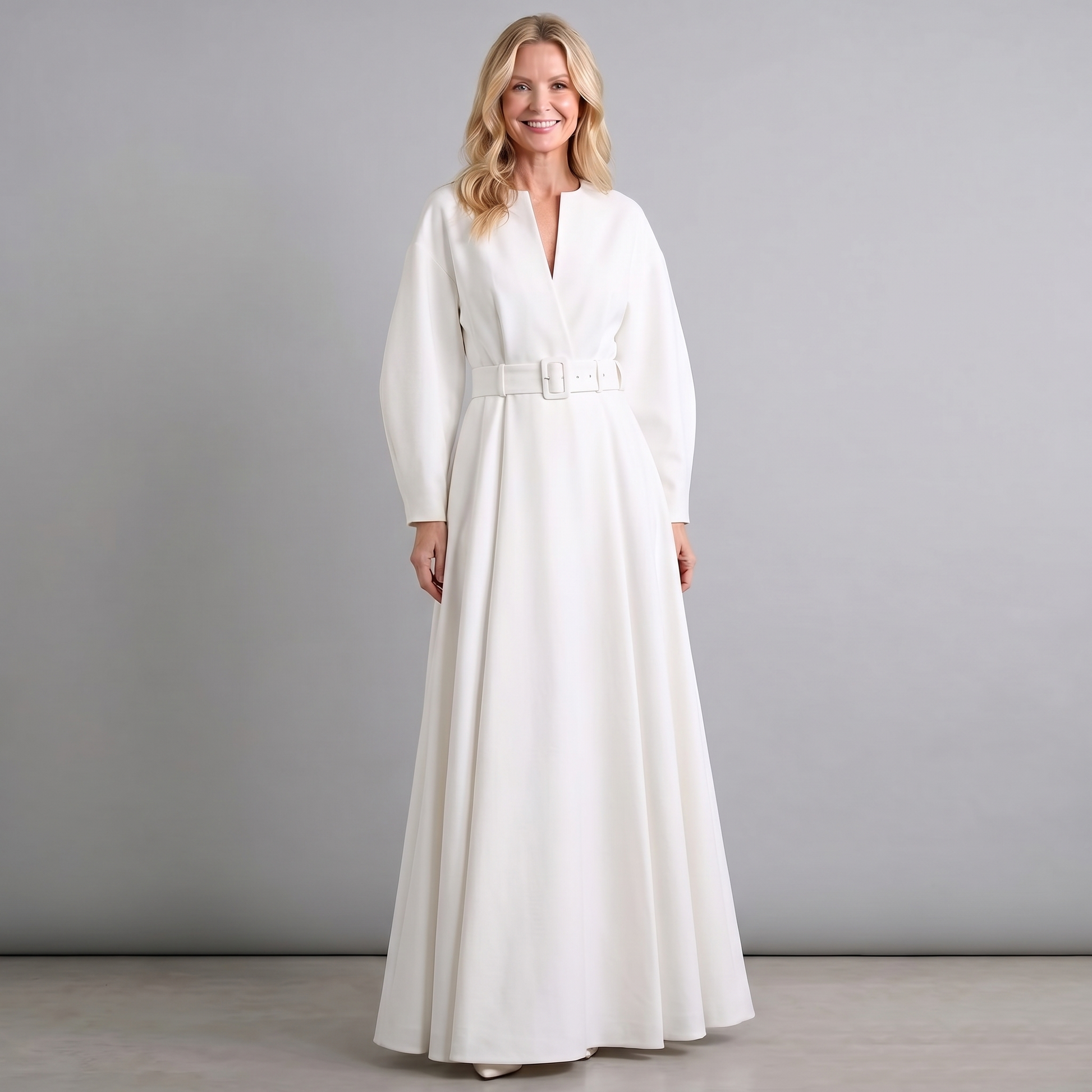 White A-line maxi dress with long sleeves, V neckline, and belted waist