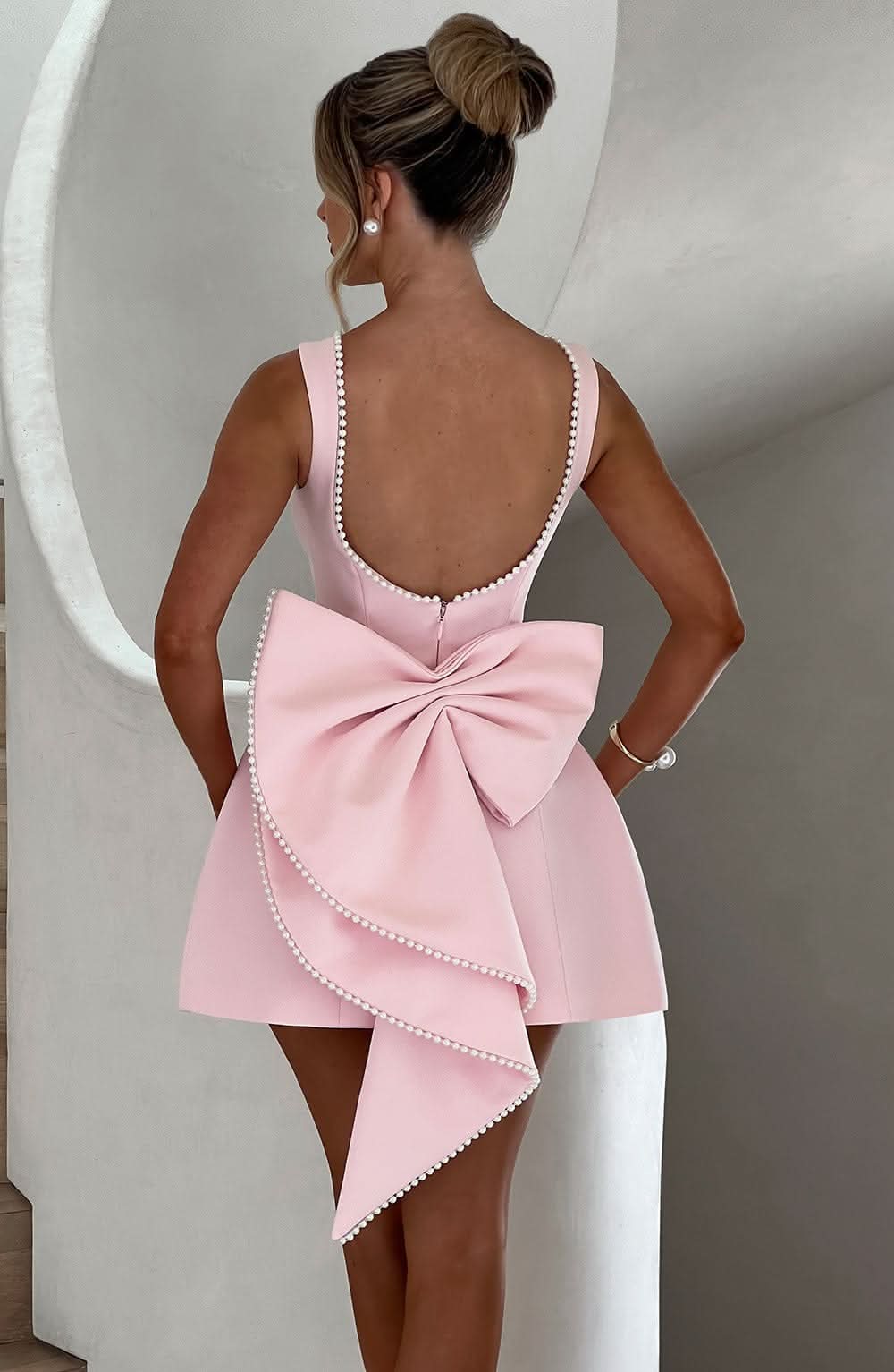 Pink A-line mini dress with bow back and pearl-trim strappy back detail