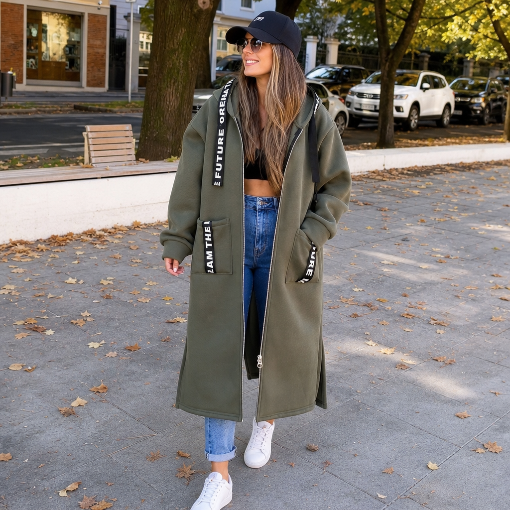 Olive green hooded longline coat with front zipper, side pockets, and printed logo straps