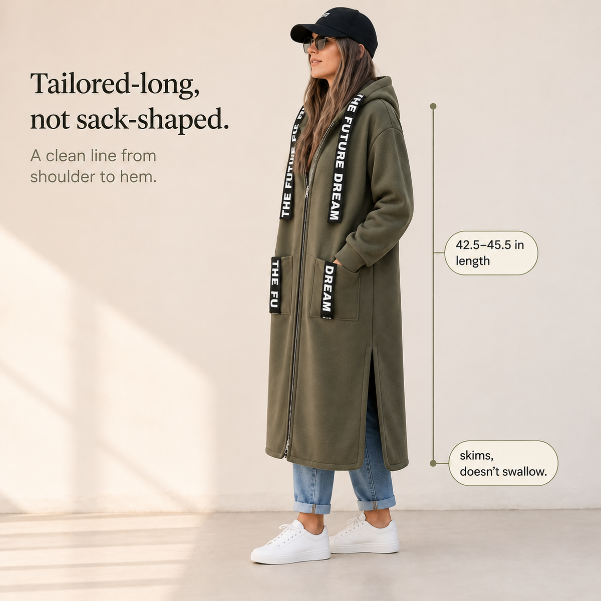 Olive green hooded longline coat with front pockets and vertical printed lettering straps