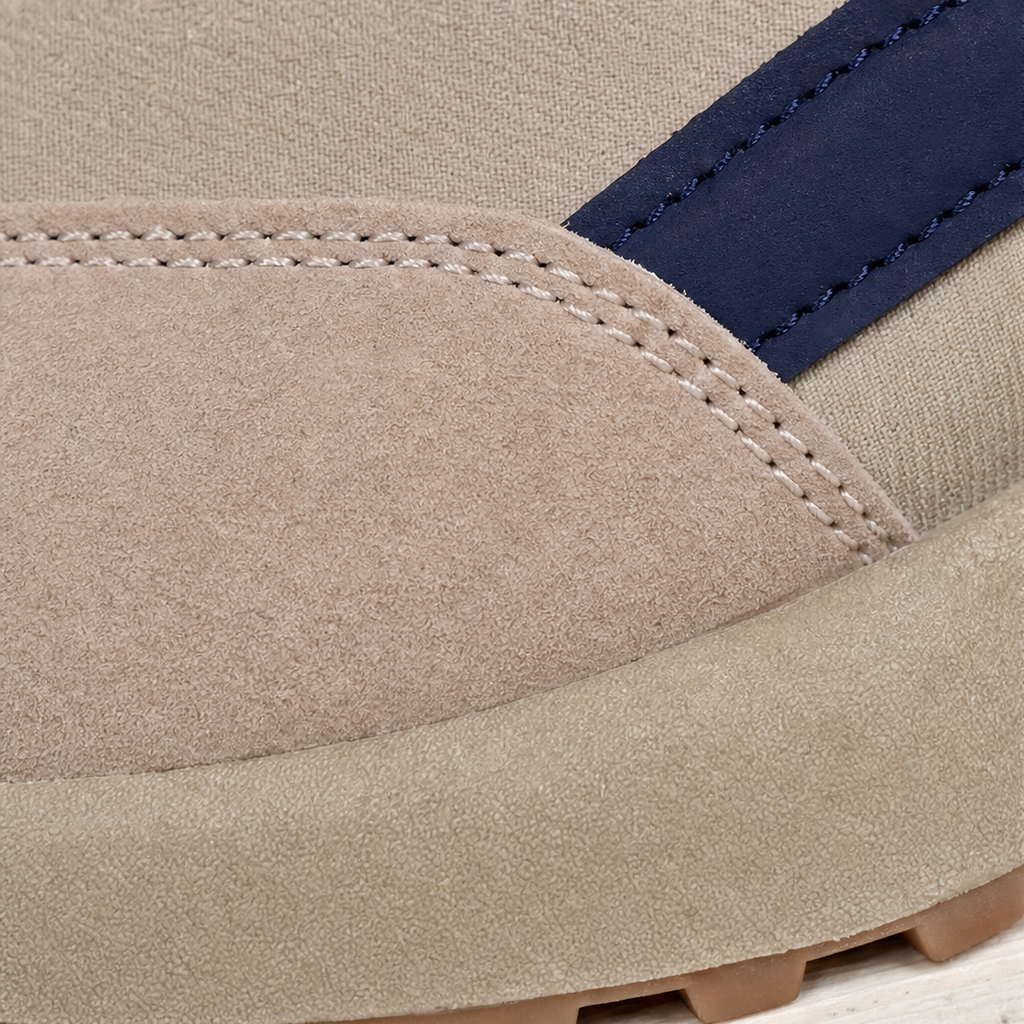 Close-up of beige suede toe and stitched lace-up panel on platform sneaker.