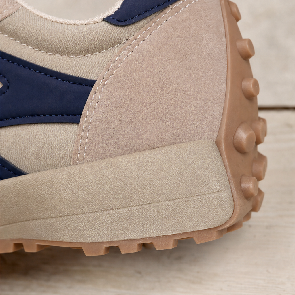 Close-up of beige side panel and navy trim on a chunky platform sneaker sole.