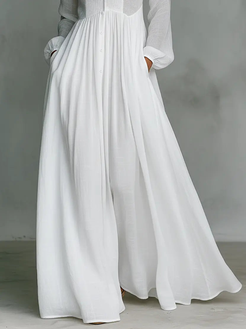 White maxi dress with gathered skirt and long sleeves, lower-body close-up