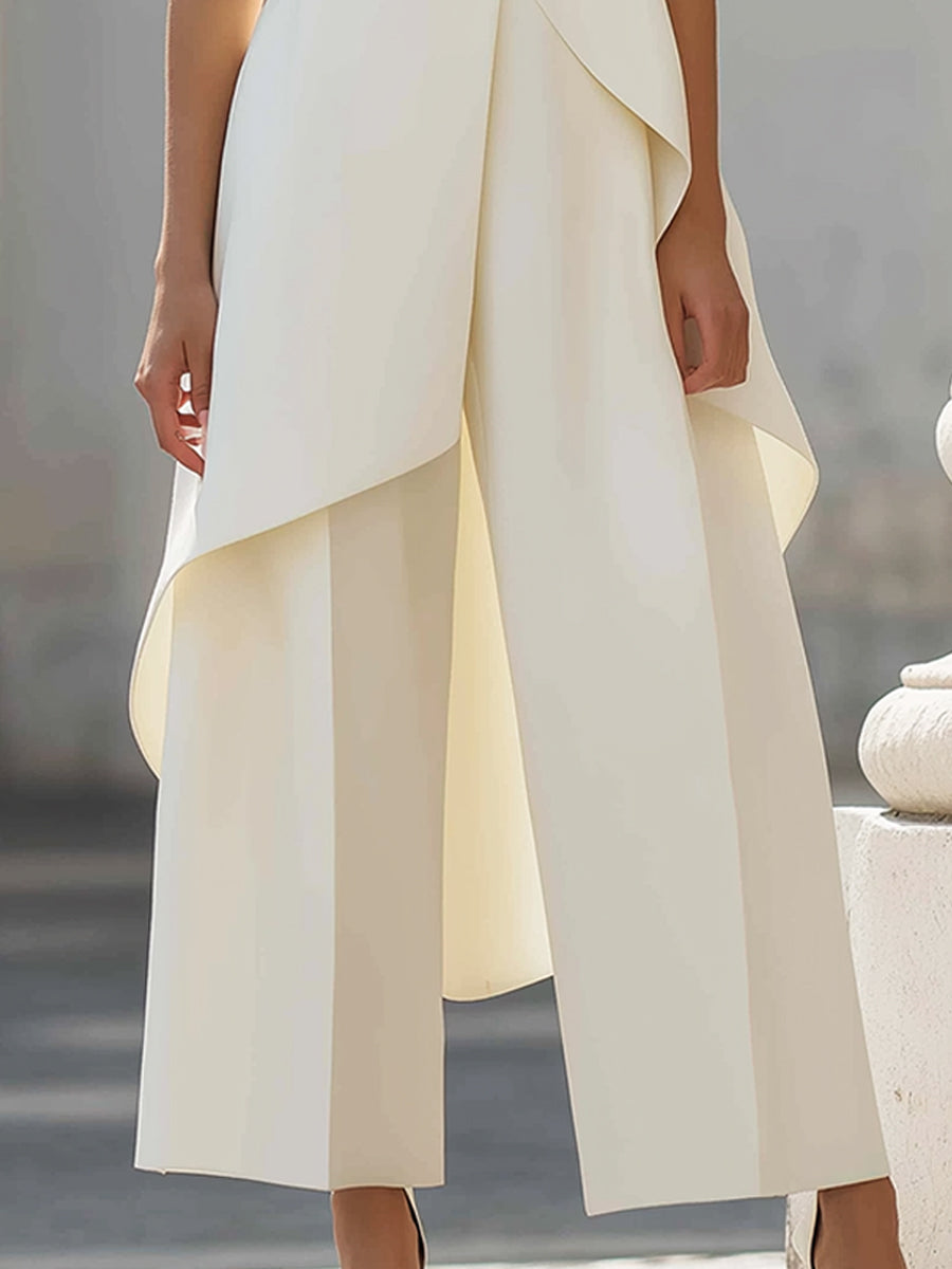 White asymmetric top with side drape over wide-leg pants