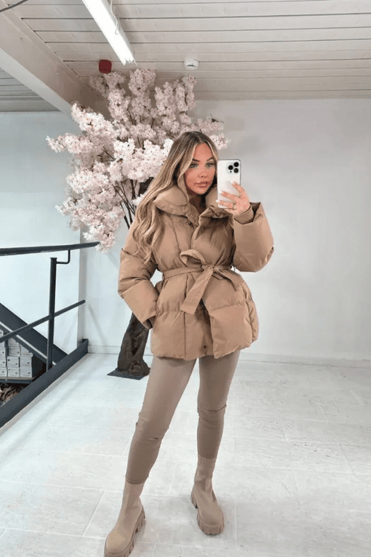 Beige belted puffer jacket with hood, button front and long sleeves.