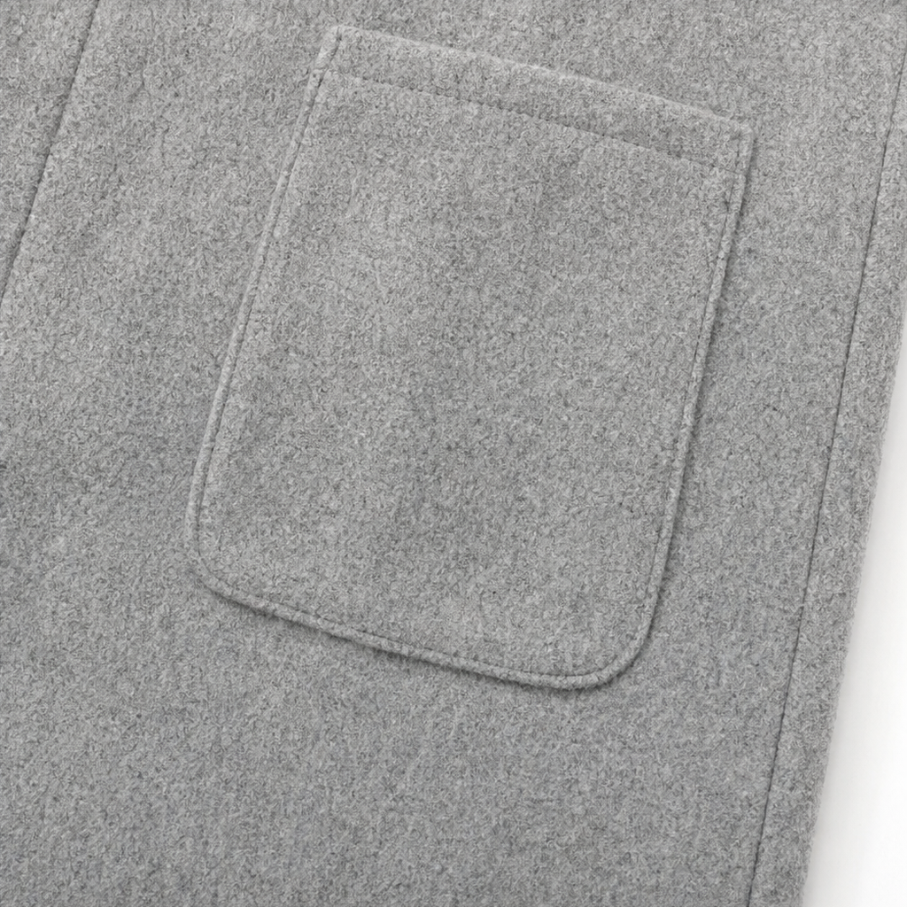 Light grey coat flap pocket with stitched border, close-up