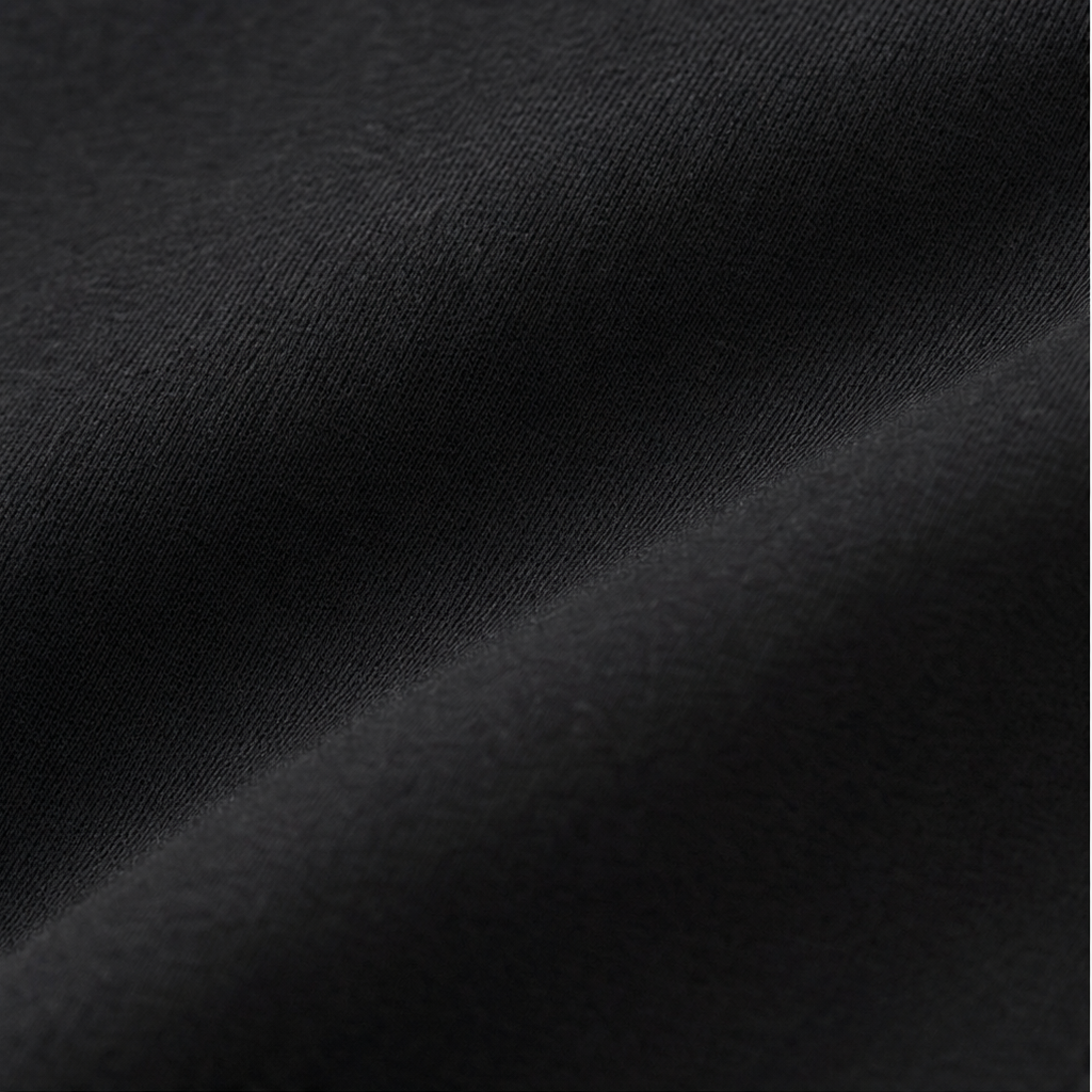 Black knit fabric close-up with fine texture, lounge set material detail.