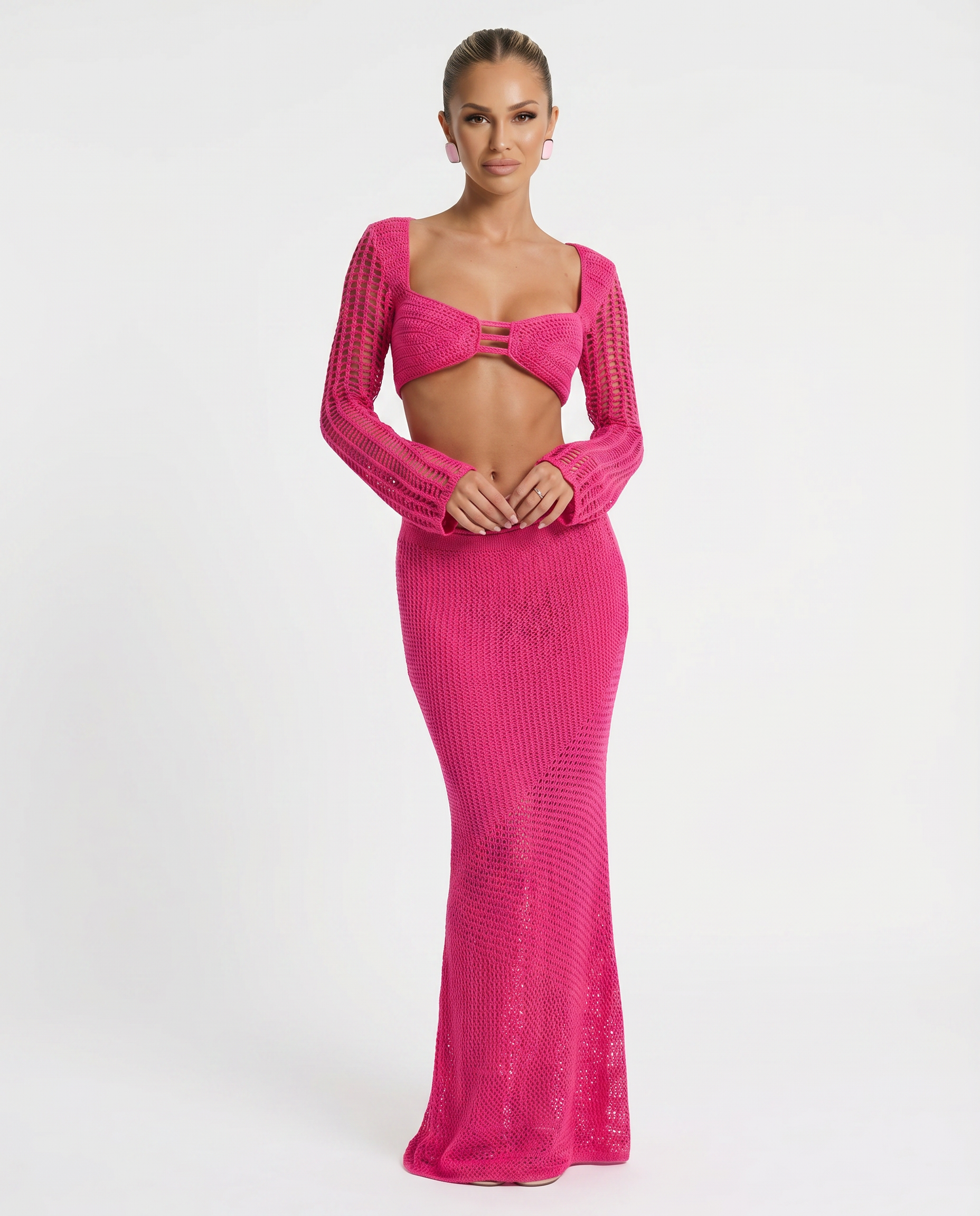 Pink crochet knit two-piece set with long sleeves, bandeau crop top and fitted maxi skirt.