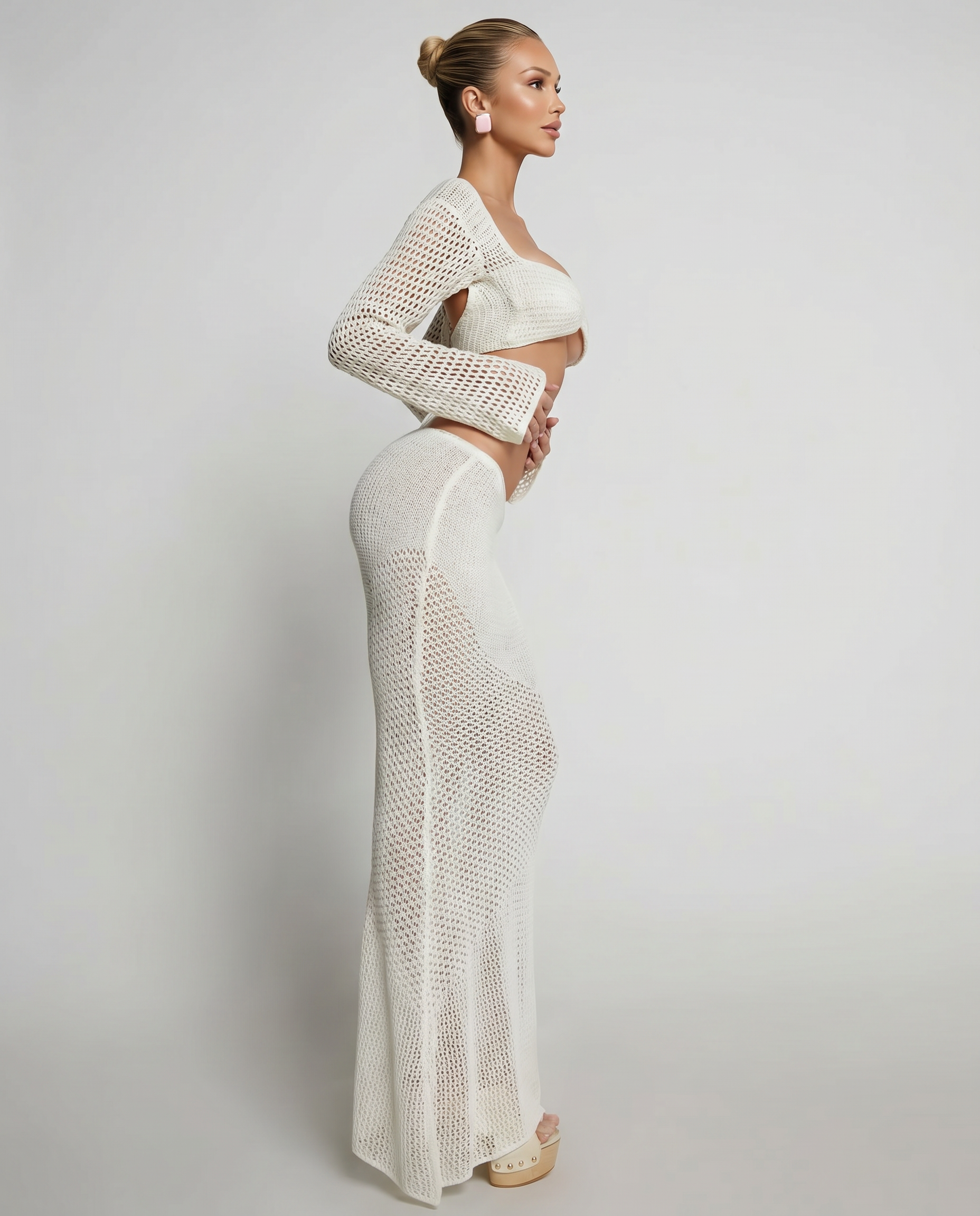 White crochet knit two-piece set with long sleeves, bandeau crop top and fitted maxi skirt.