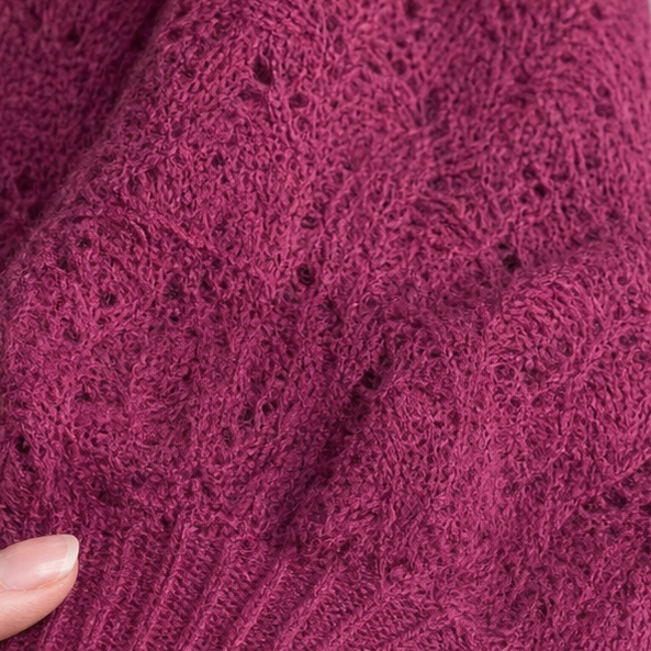 Close-up of purplish-red openwork knit texture with small diamond-like holes