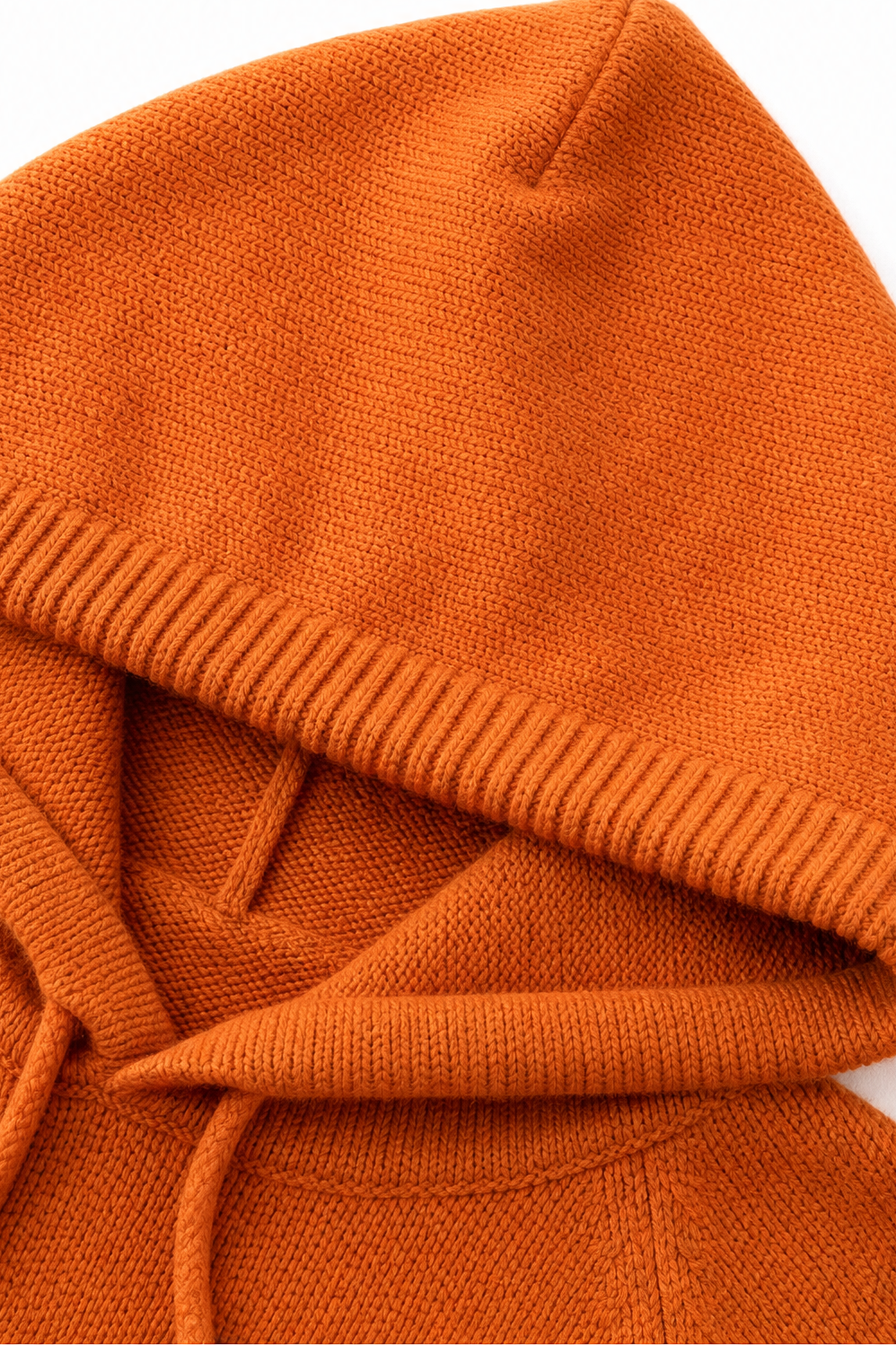Close-up of orange knit hooded pullover fabric and ribbed trim