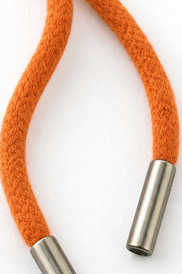 Close-up of orange drawstring with metal aglets on a hood