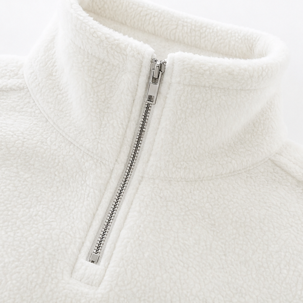Close-up of cream white quarter-zip pullover with zipper track and stand collar