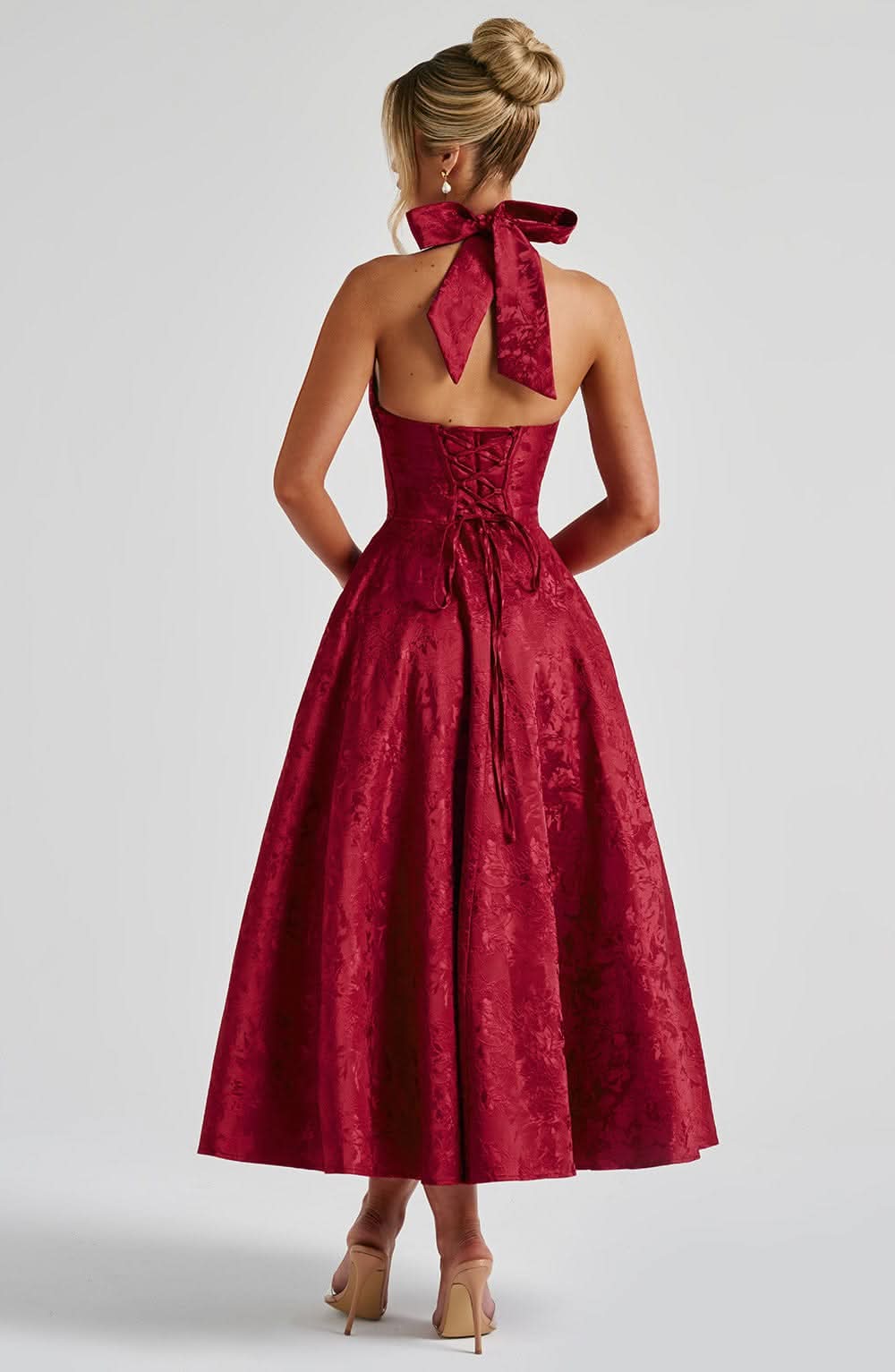 Red halter midi dress, open-back with ribbon bow and pleated floral jacquard skirt