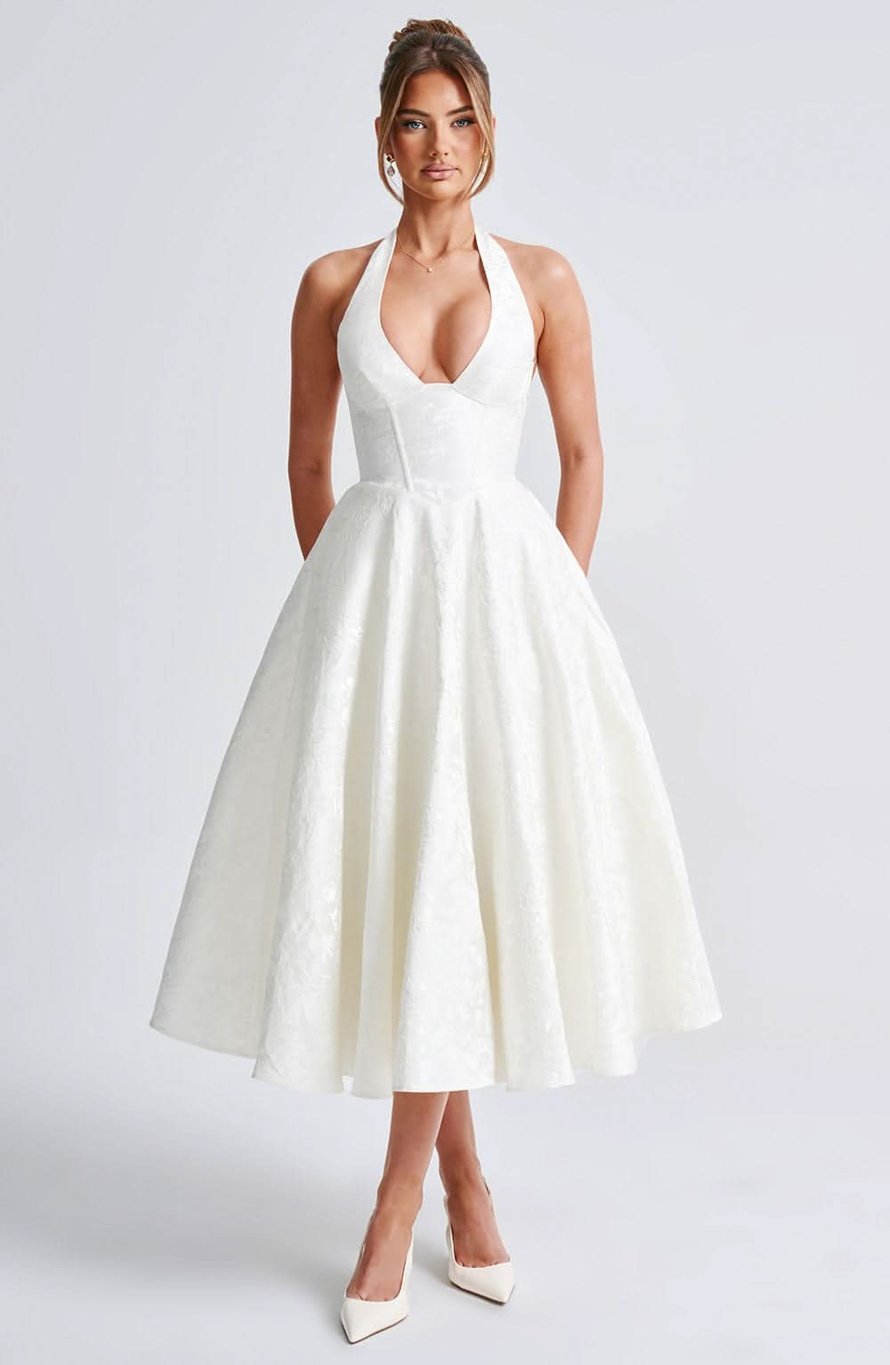 White halter midi dress with deep V neckline and floral jacquard flared skirt