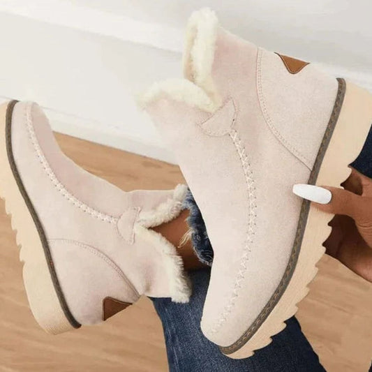 Beige faux-fur lined ankle boots with suede uppers and dark trim