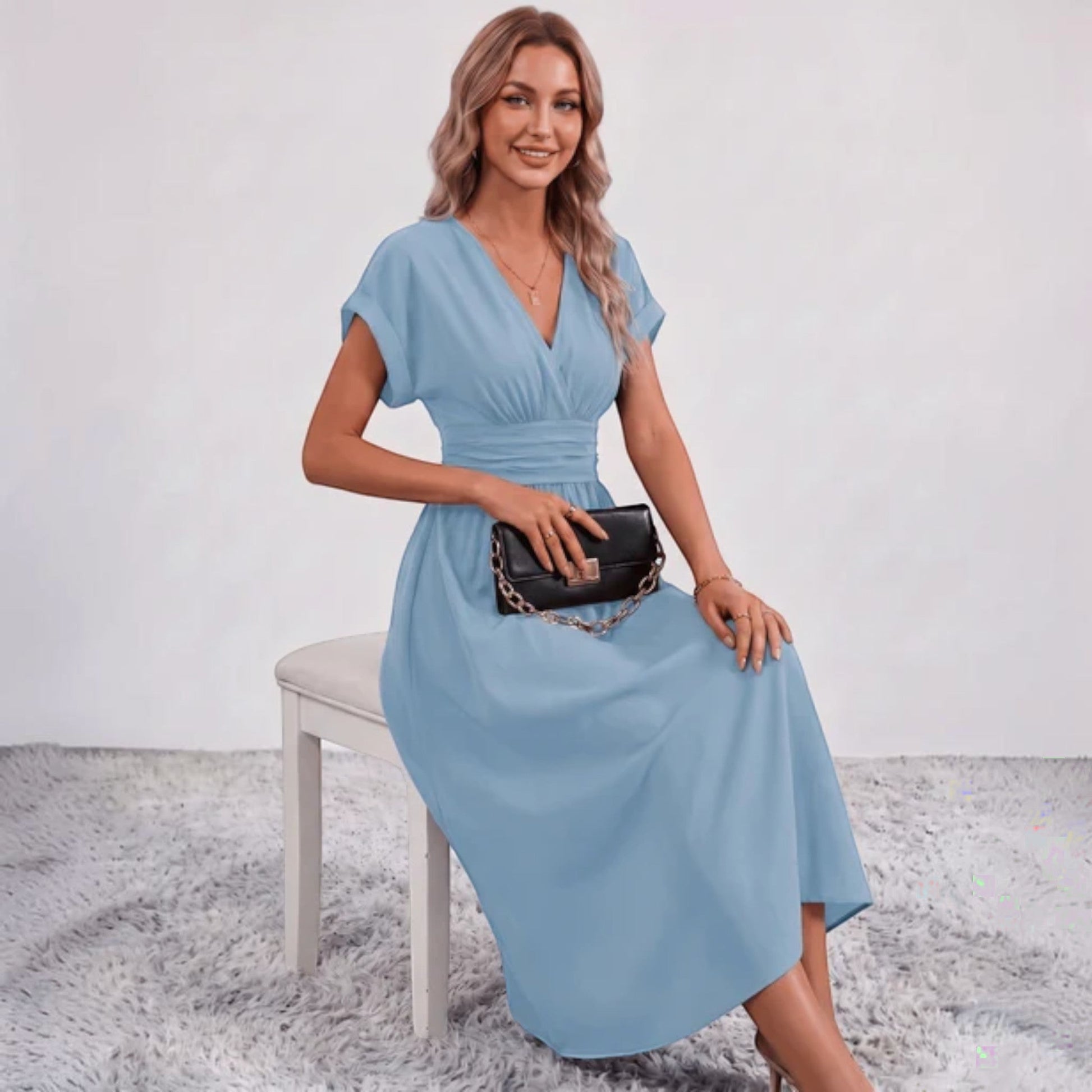 Blue V-neck midi dress with ruched waist, short sleeves, and flared skirt, seated