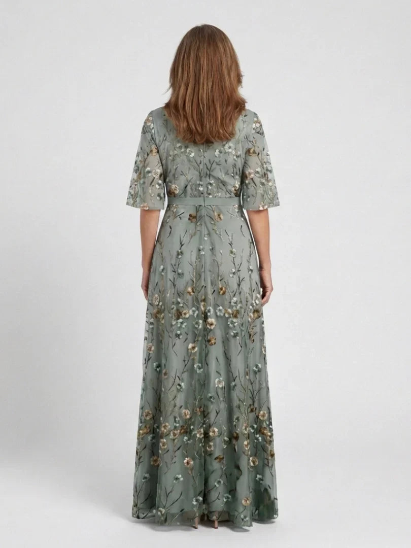 Back view of sage green floral maxi dress with V-neck detailing and belted waist