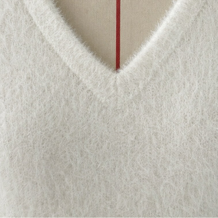 Close-up of white V-neckline knit with stitched edge detail