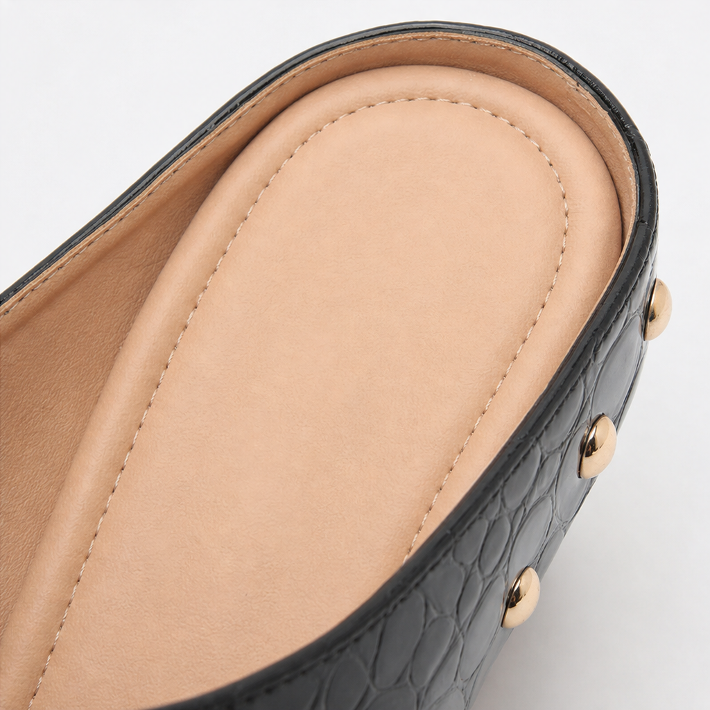 Black croc-embossed clog mule interior with tan lining and gold dome stud detail