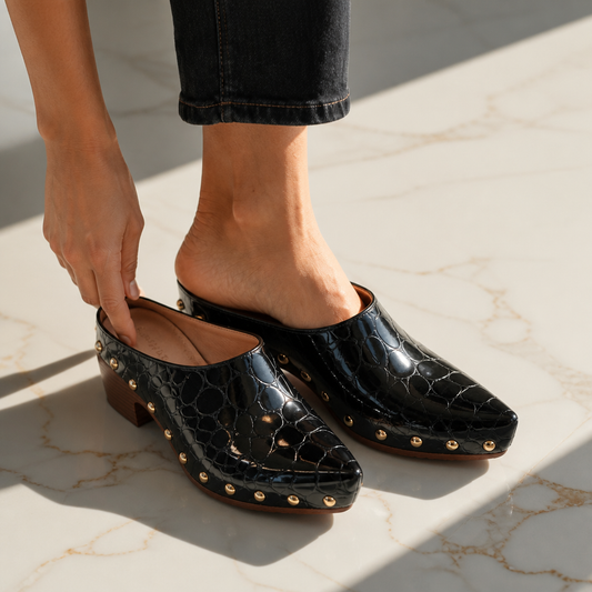 Black croc-embossed clog mules with gold dome studs on side and mid-height wood heel