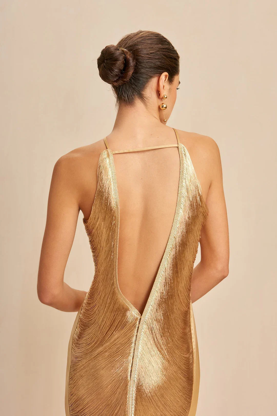 Backless gold halter maxi dress with V-back and metallic fringe panels