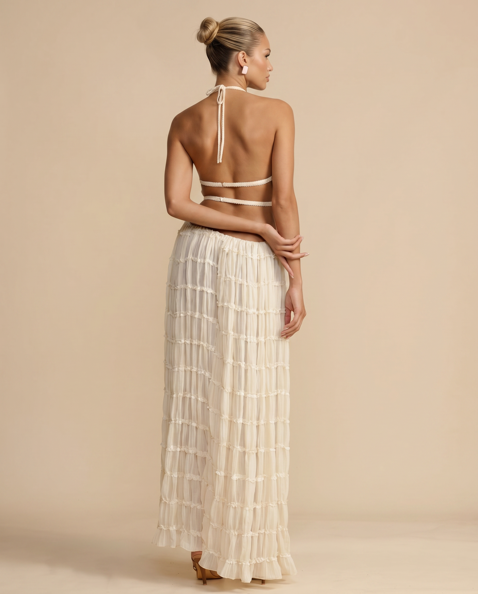 Ivory halter backless crop top and pleated tiered maxi skirt, back view