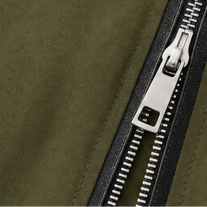 Olive green jacket zipper close-up with silver pull and teeth detail