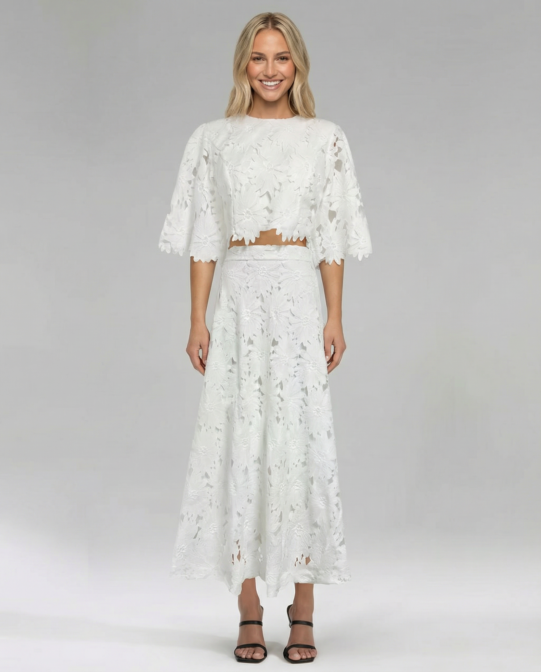 White lace crop top and maxi skirt set with floral embroidery, smiling front view