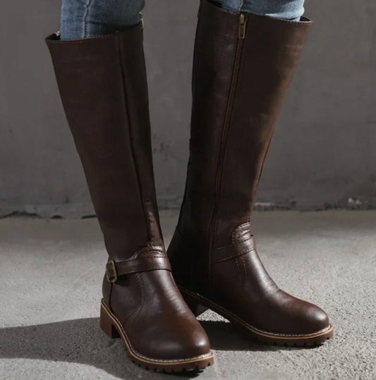 Leather knee-high boots in dark brown with buckle strap and rugged outsole.