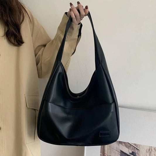 Black leather hobo shoulder bag, curved opening with short handles.