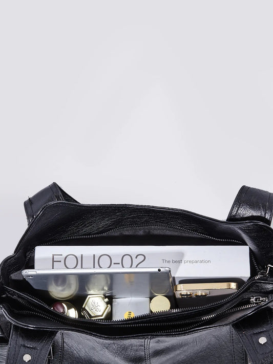 Black leather shoulder bag open-top view showing interior pockets and zipper trim