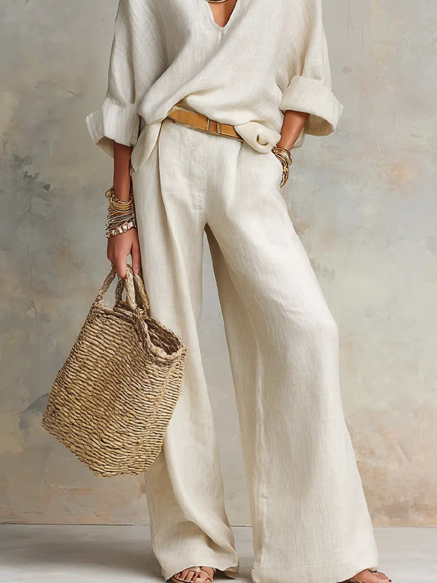 White linen two-piece set close-up: loose blouse and wide-leg trousers, belt