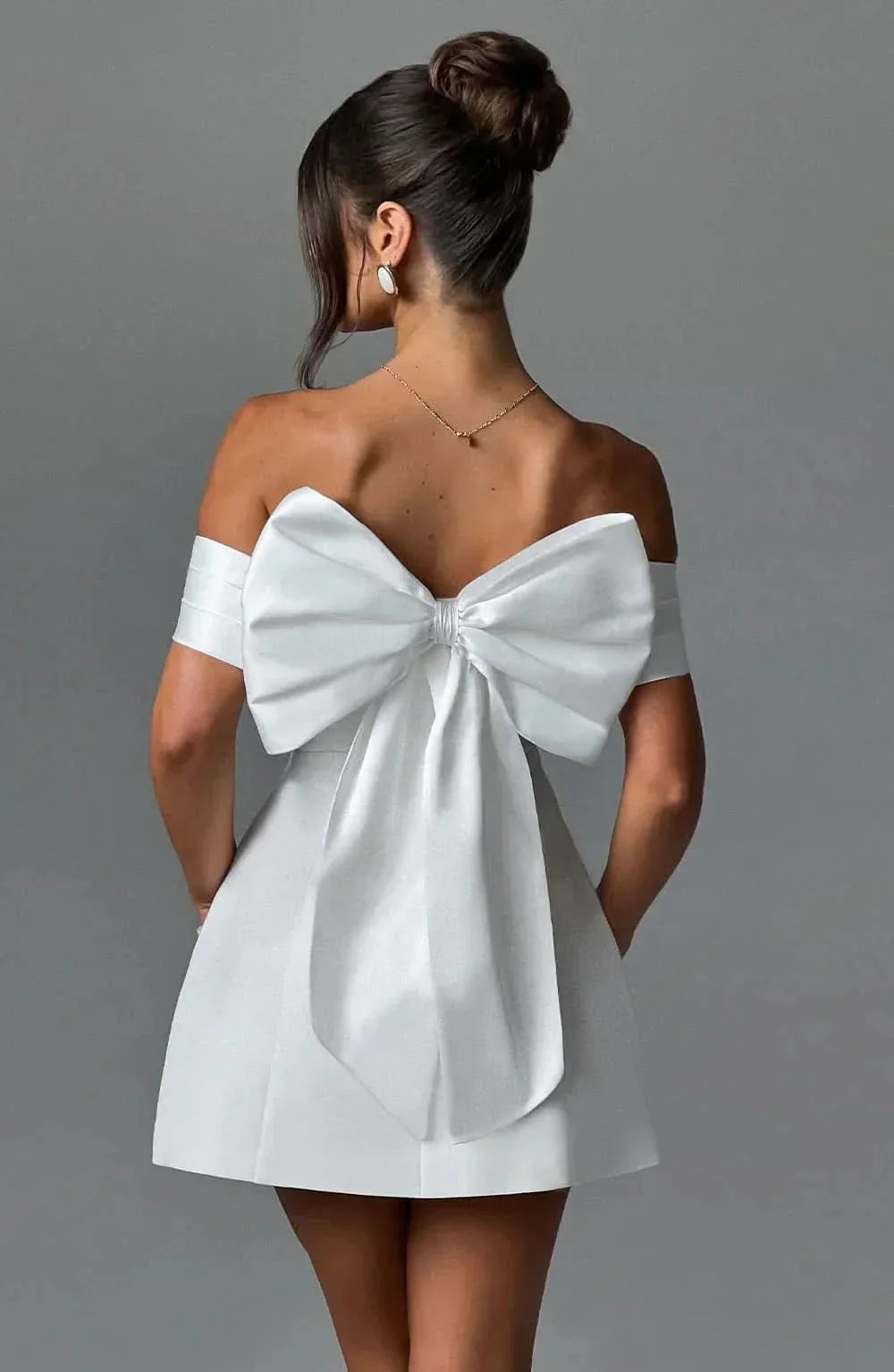 White off-shoulder mini dress with large back bow and short flared skirt