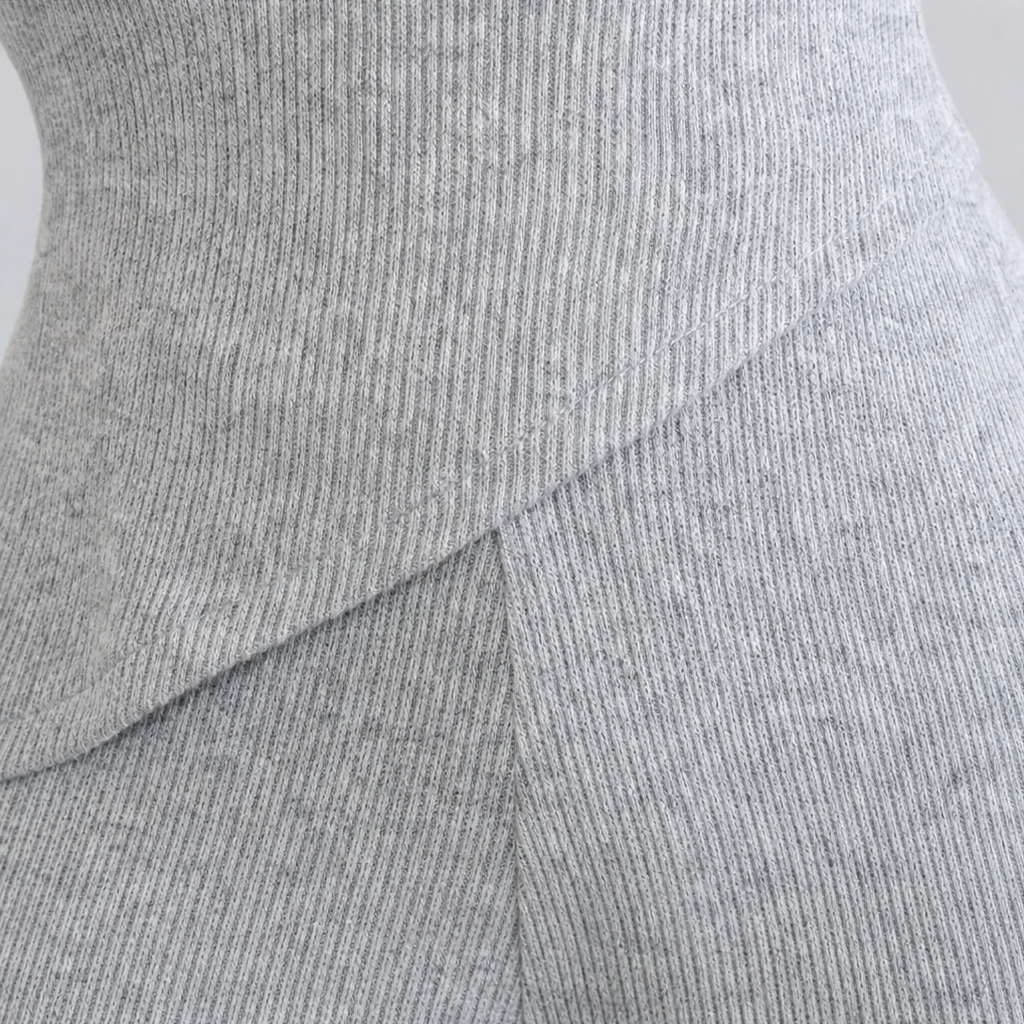 Light gray ribbed knit top drape detail with diagonal fold seam close-up