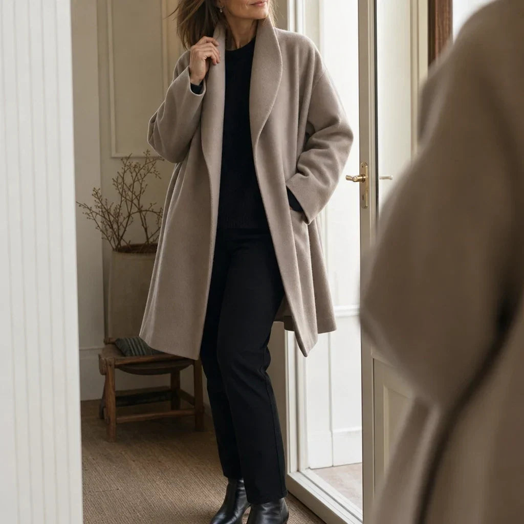 Oversized taupe coat worn open, showing its long cut and wide lapels.