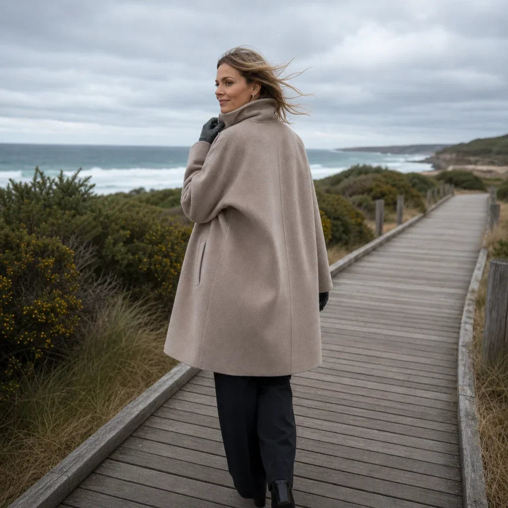 Back view of a taupe oversized coat with a loose silhouette and long sleeves.