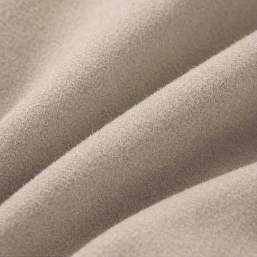 Taupe coat fabric close-up showing a soft, fine-textured surface.