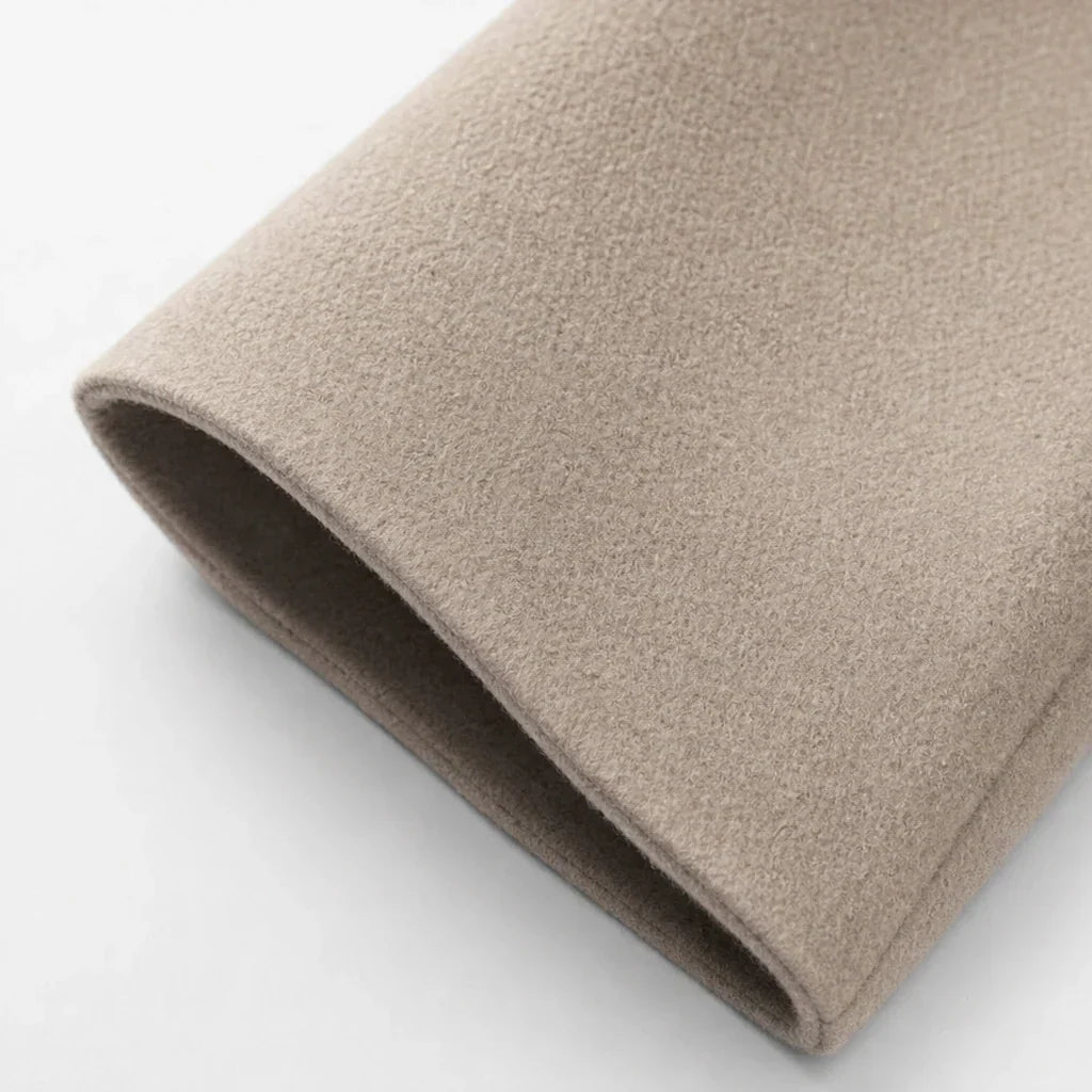 Taupe oversized coat fabric close-up with a smooth, folded edge
