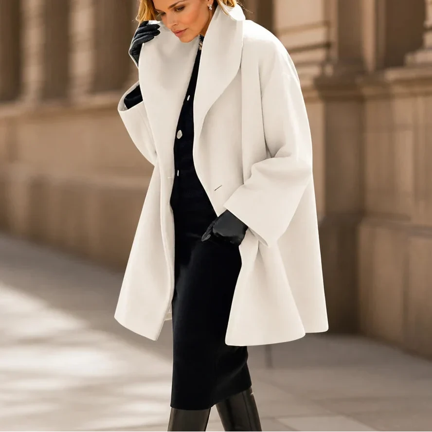 White oversized coat with wide lapels, long sleeves, and a flared hem