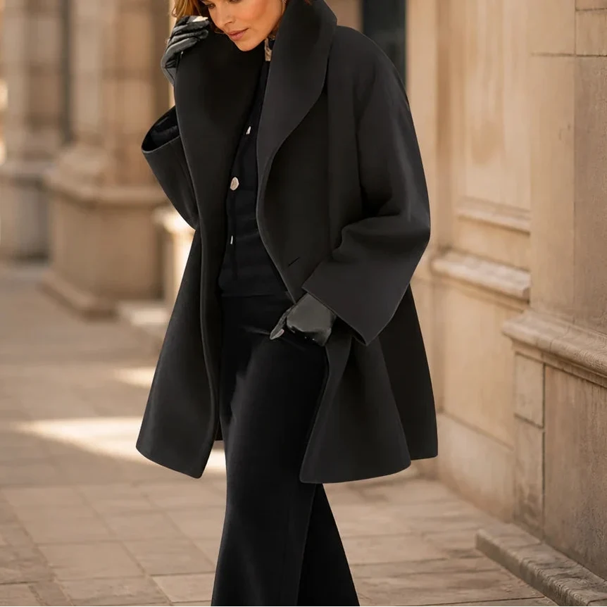 Black oversized coat with wide lapels and a relaxed, mid-thigh cut