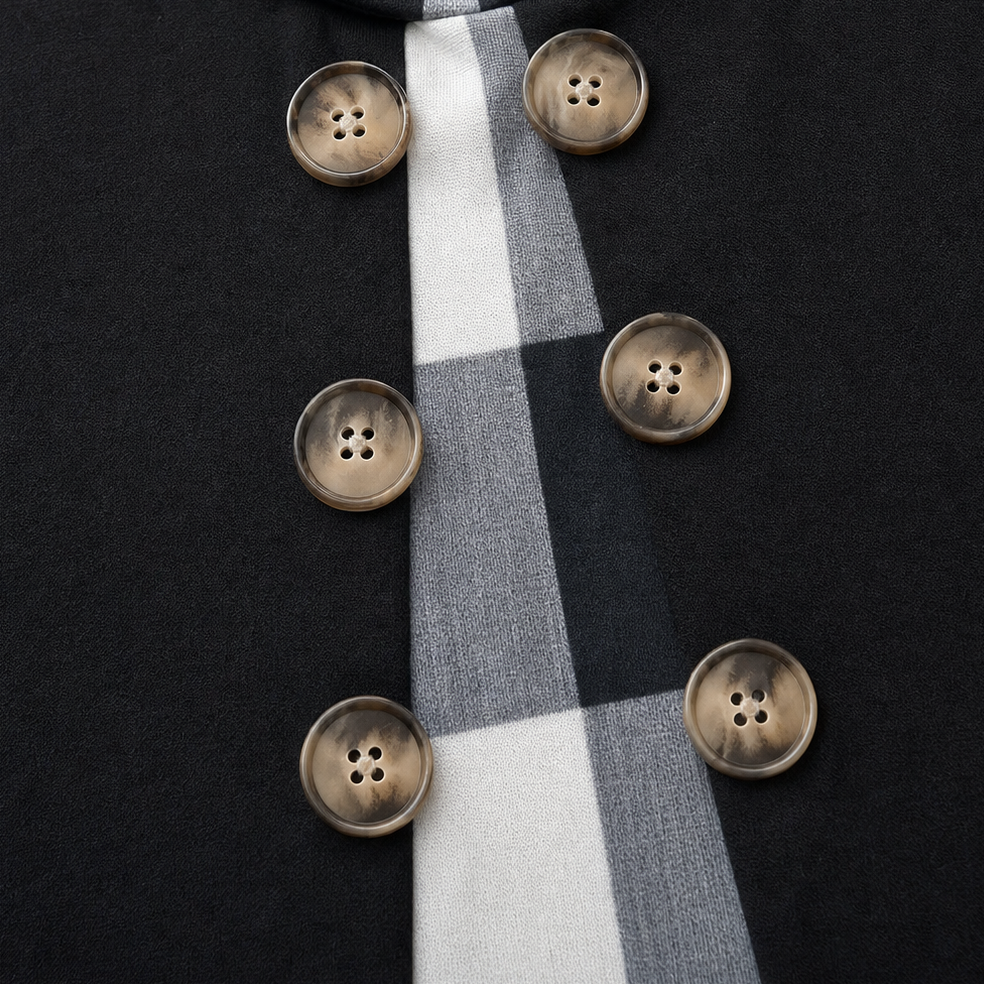 Gold button detail on black tunic with vertical plaid panel