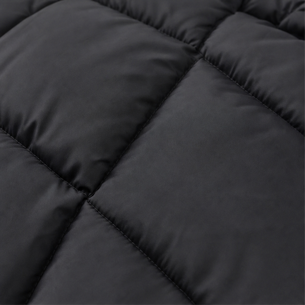 Black quilted padded coat panel with stitched baffles and smooth outer fabric.