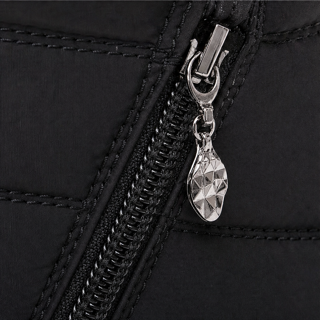 Close-up of black side zipper and metal zipper pull on ankle boot.