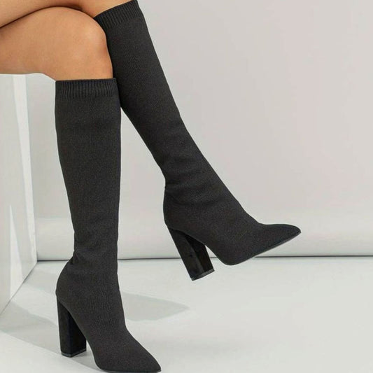 Black ribbed knit knee-high boots with block heel, pointed toe and snug fit.