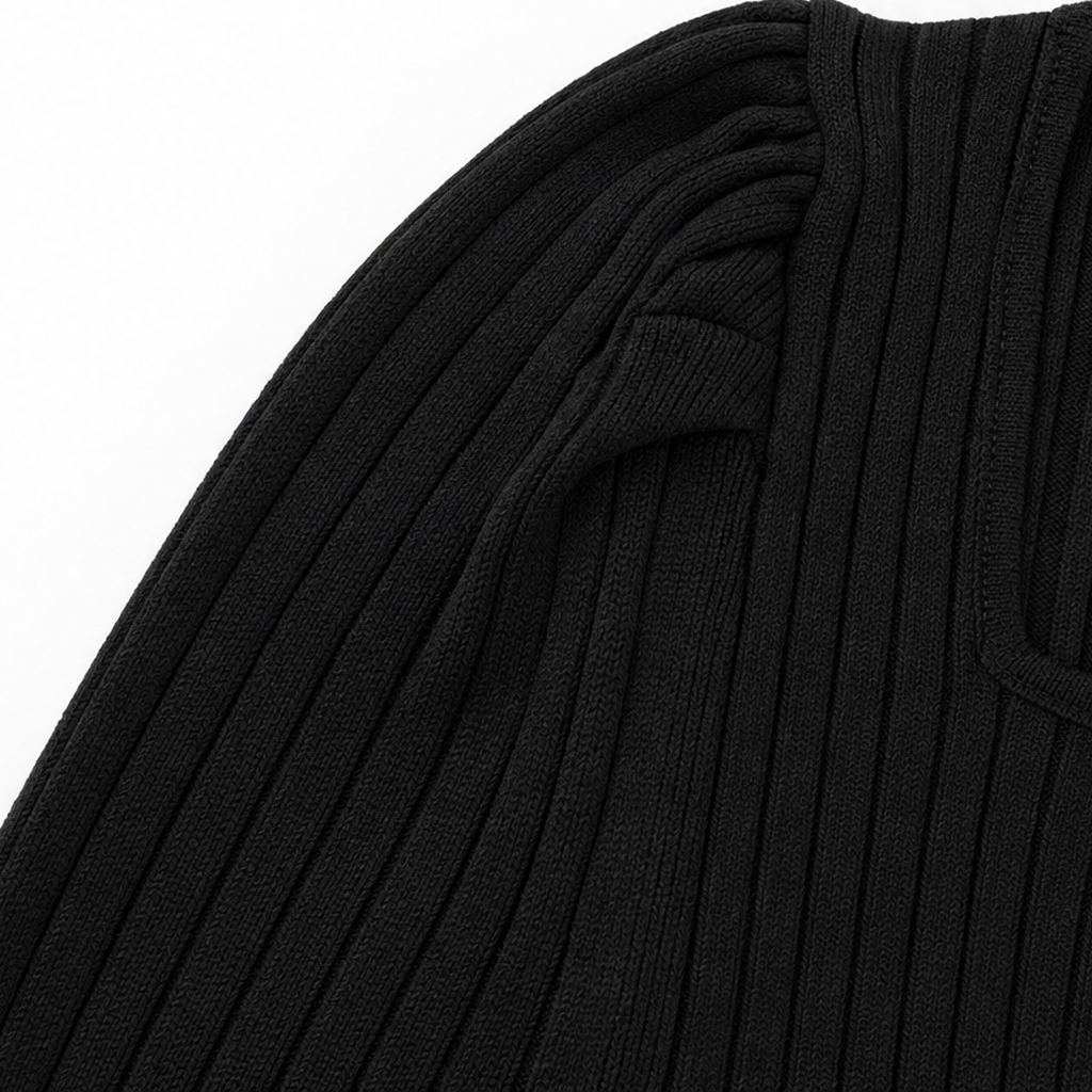 Close-up of black ribbed knit sleeve with fold and seam detail
