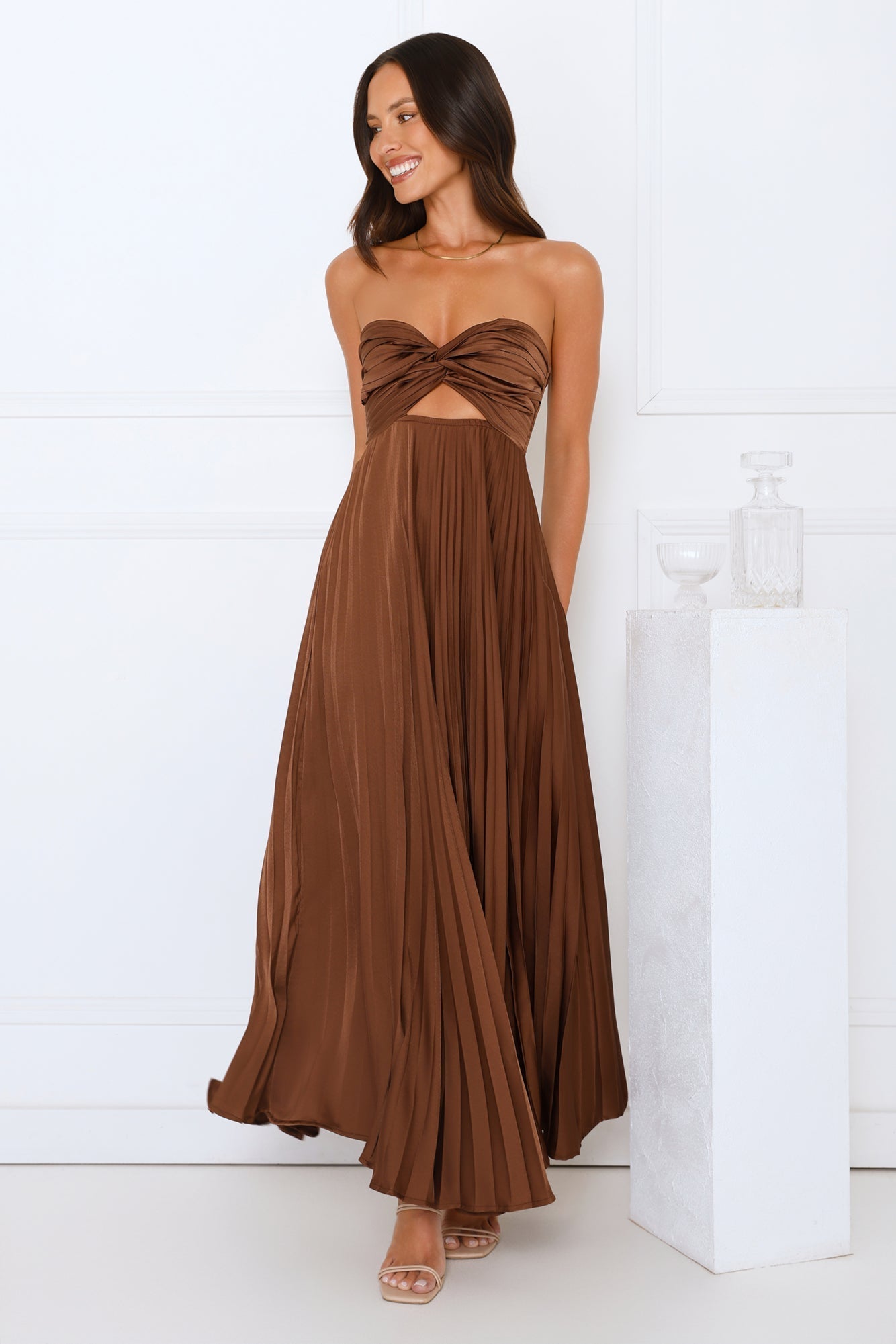 Brown satin strapless maxi dress with front knot and flowing pleated fabric