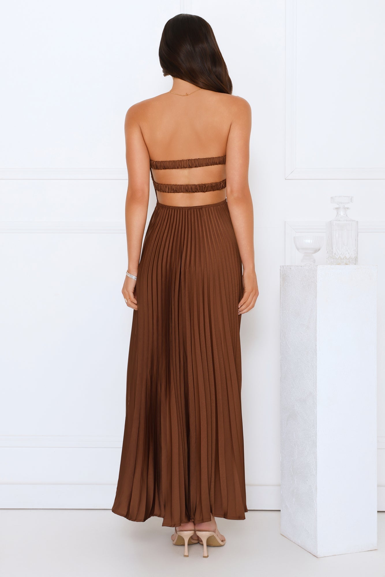 Brown satin maxi dress with open-back cutout and strap detail, strapless front