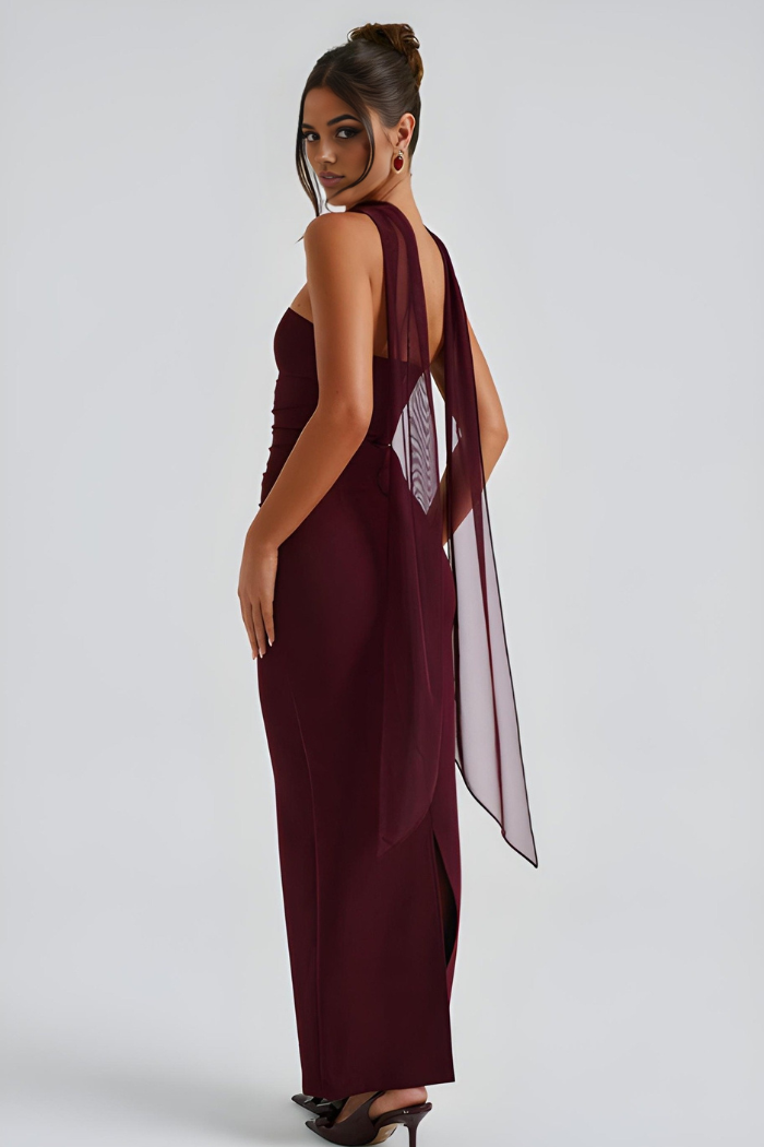 Burgundy strapless bodycon maxi dress from side view with flowing scarf drape