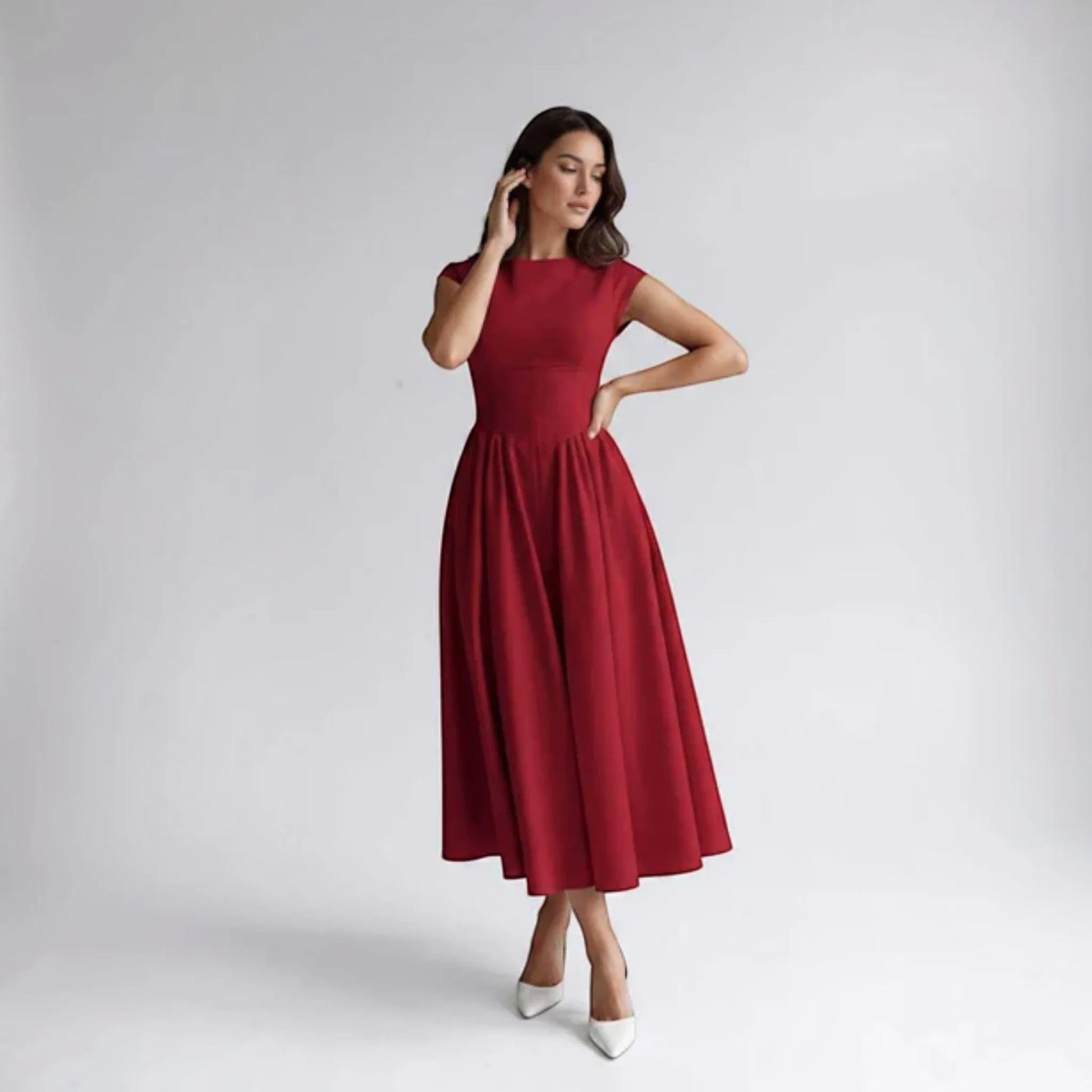 Red sleeveless fit-and-flare midi dress, side-front view with flared pleated hem